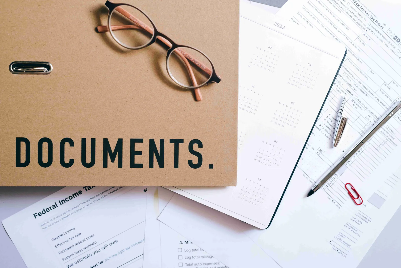 A folder clearly labeled as Documents next to glasses and a pen