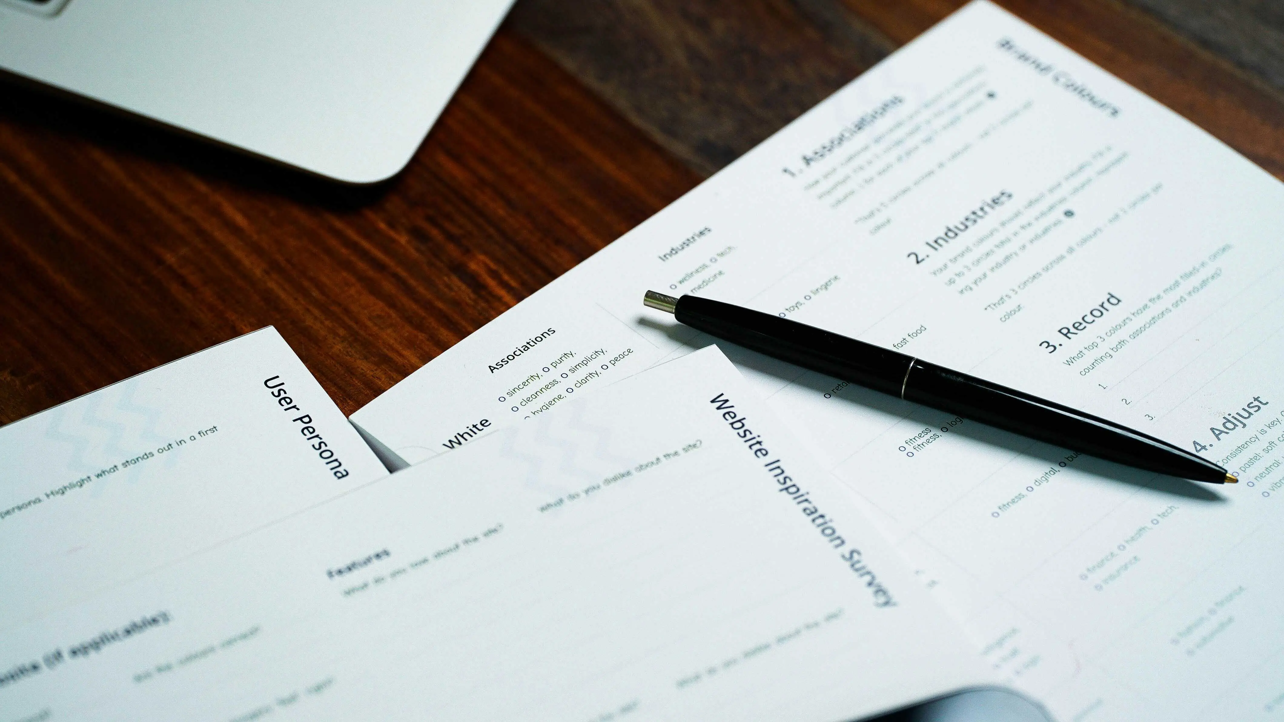 Official documents with a black pen on a dark wooden table