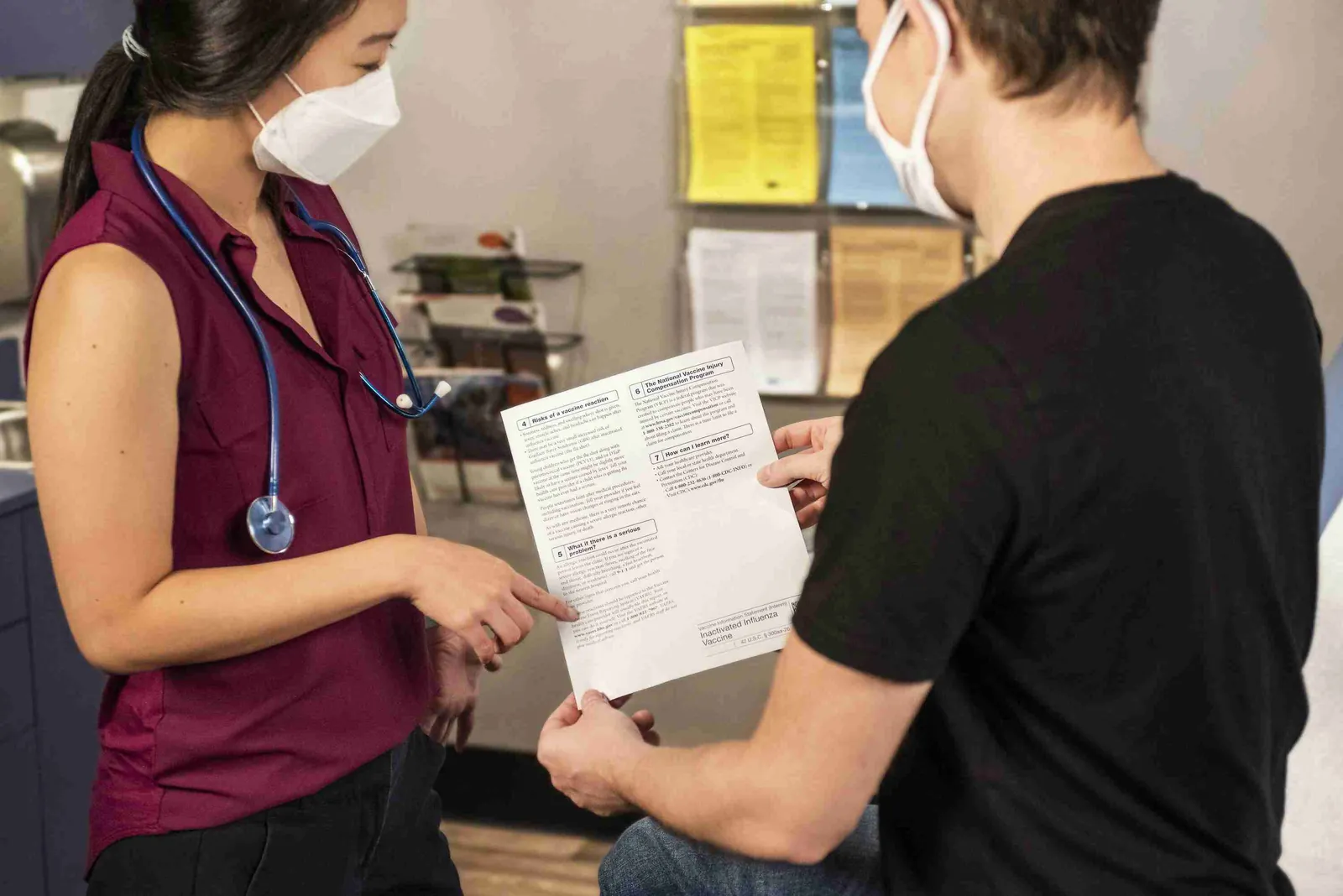 A woman passing a document or medical form to a man