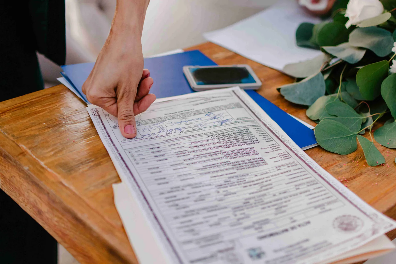 A person pointing with their finger at text details inside a contract
